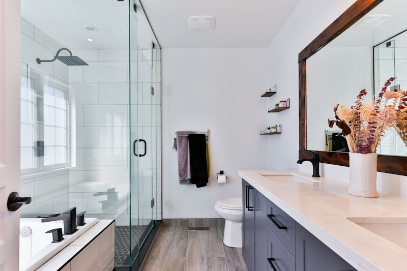 Remodeled bathroom with tiled walk-in shower and navy vanity